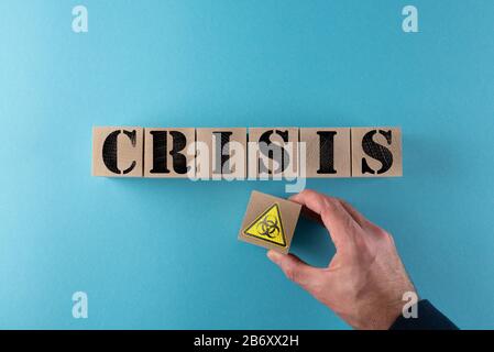 Vista superior de la palabra CRISIS y advertencia de peligro biológico en cubos de madera, amenaza biológica y concepto de crisis de virus