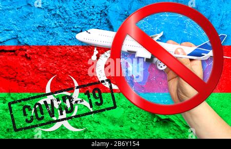 La nueva enfermedad coronavirus llamada COVID - 19, con la bandera de Azerbaiyán frente a una pared agrietada, contiene el concepto de una prohibición de viajar en avión betw Foto de stock
