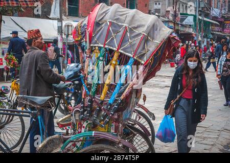 Katmandú, Nepal 25 de febrero de 2018 Rickshaw en medio de una calle muy transitada Foto de stock