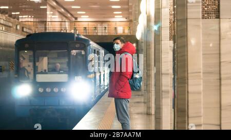 El joven europeo en máscara médica desechable protectora en el metro. Nuevo coronavirus (COVID-19). Concepto de atención de salud durante una epidemia Foto de stock