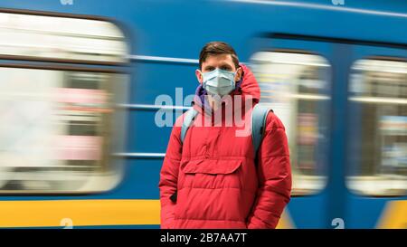 El joven europeo en máscara médica desechable protectora en el metro. Nuevo coronavirus (COVID-19). Concepto de atención de salud durante una epidemia Foto de stock