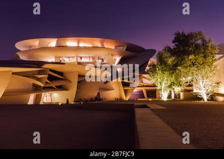 Foto nocturna del Museo Nacional de Qatar, con su llamativo diseño en disco, en Doha, Qatar