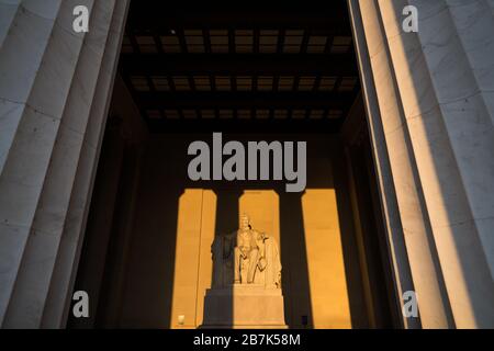 WASHINGTON DC, EE.UU. - la gran estatua en el interior de la sala principal del Lincoln Memorial, atrapar la luz dorada del sol por la mañana temprano al amanecer durante el otoño (equinoccio de otoño). El Lincoln Memorial se encuentra en el extremo occidental de la piscina reflectante y enfrenta directamente al este. La estatua es profundo dentro de la cámara y está normalmente fuera del alcance de la luz solar directa.