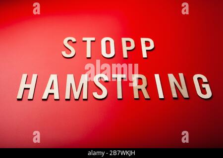stopp hamstring texto noruego palabra madera carta sobre fondo rojo coronavirus covid-19 Foto de stock