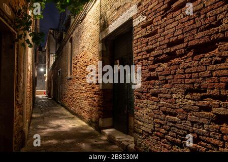 Antiguo Brickwall en un callejón estrecho en el distrito de Cannaregio, Venecia/Italia Foto de stock