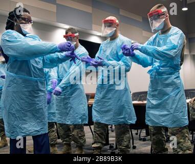 Los miembros de la Guardia Nacional de Florida están entrenados en donar equipo de protección personal por el personal del hospital en un centro de pruebas COVID-19 el 17 de marzo de 2020 en el Condado de Broward, Florida. Foto de stock