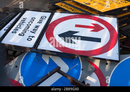 Varios carteles metálicos británicos de carretera en el recinto de almacenamiento en espera de uso.