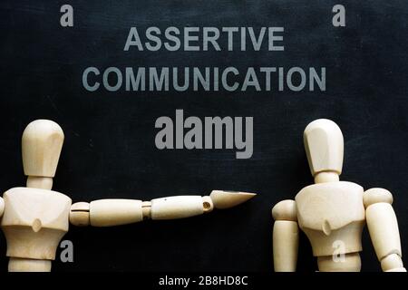 Frase de comunicación asertiva y dos figuras de madera. Foto de stock