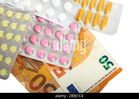 Pastillas y cápsulas en ampollas de billetes en euros. El concepto de medicamentos caros y tratamiento Foto de stock