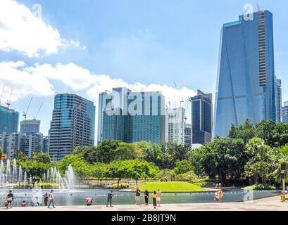 Oficinas y torres residenciales de gran altura y fuentes en el Lago Symphony y los turistas disfrutar de un día en el Parque KLCC Kuala Lumpur Malasia.