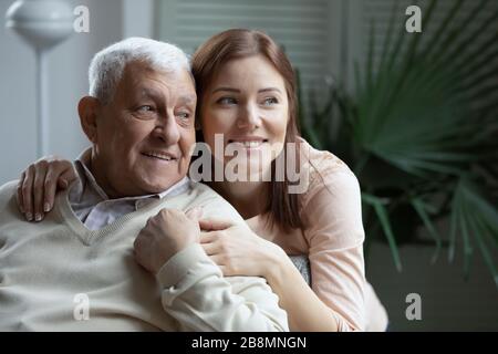 Una nieta mayor con un abuelo mayor lo abraza hablando al aire libre