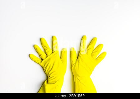 dos manos en guantes de látex amarillo sobre fondo blanco. limpieza, limpieza de muelles Foto de stock