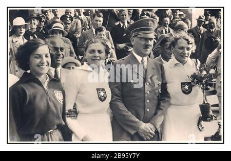 ADOLF HITLER Vintage Olimpiadas 1936, 'Juegos Olímpicos en Berlín' Fuhrer Adolf HITLER con Tilly Fleischer, a la derecha, que obtuvo la primera medalla de oro para Alemania en los Juegos Olímpicos en el evento de jabalina con 45,18meters. De izquierda a derecha: Srta. Kwaniewska (Polonia) (BRONCE), Srta. Kreuger (Alemania) (PLATA), Adolf Hitler y Miss Fleischer Alemania (ORO) Foto de stock