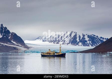 MS Origo, barco con eco-turistas frente a Monacobreren, glaciar en Haakon VII Tierra que se desglega en Liefdefjorden, Spitsbergen / Svalbard, Norwa