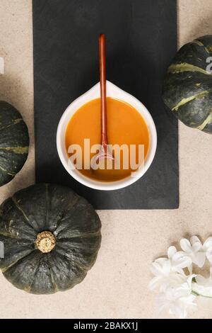 Vista superior imagen de sopa de calabaza en un Bol con cuchara de madera y decoraciones Foto de stock