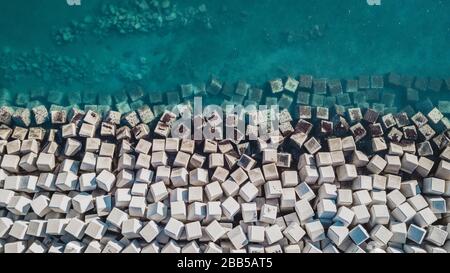 Vista aérea de bloques de cemento que protegen la costa de las olas del puerto de Málaga, España. Foto de stock