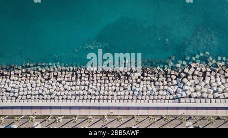Vista aérea de bloques de cemento que protegen la costa de las olas del puerto de Málaga, España. Foto de stock