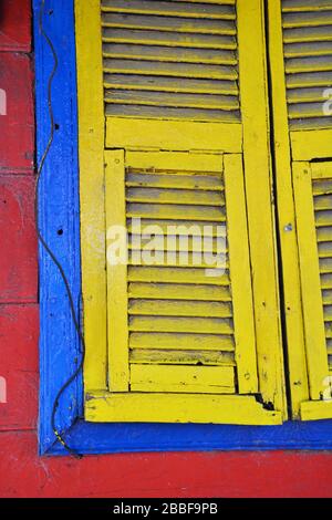 Buenos Aires, Argentina-Febrero 2019: Vista de cerca de parte de la ventana con persianas en rojo, azul y amarillo en la casa en el distrito de la Boca en Bueno