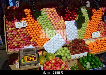 Mercado de calle con frutas coloridas. Caja de madera con pequeña bandera de Sri Lanka. Pequeña empresa para la venta de alimentos saludables. Kandy, Sri Lanka Foto de stock