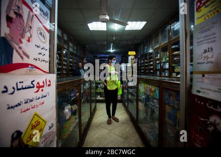 Shubra al Khaymah, Egipto. 03 de abril de 2020. Un voluntario usando una máscara facial rocía desinfectante en un paraharmacy para ayudar a frenar la propagación del coronavirus (Covid-19). Crédito: Gehad Hamdy/dpa/Alamy Live News