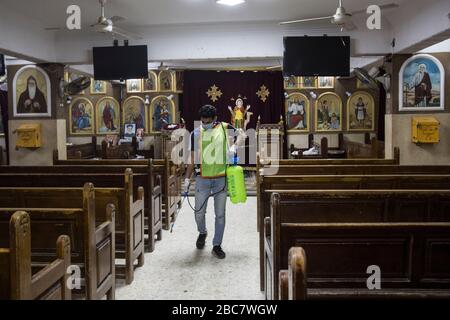Shubra al Khaymah, Egipto. 03 de abril de 2020. Un voluntario que usa una mascarilla facial rocía desinfectante en la Iglesia de San Mina para ayudar a frenar la propagación del coronavirus (Covid-19). Crédito: Gehad Hamdy/dpa/Alamy Live News