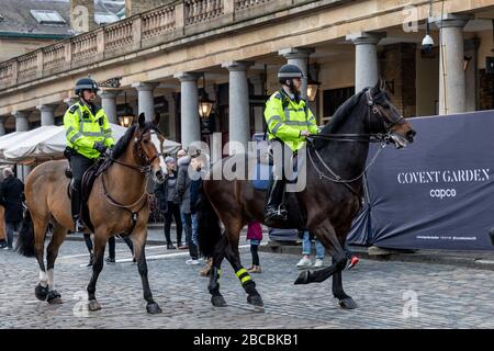 Oficiales de Policía Metropolitana patrullando a caballo en Covent Garden, Londres Foto de stock