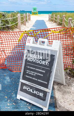 Miami Beach Florida, South Beach, Spring Break cerrado playas públicas signo de advertencia de la policía, asesoramiento de salud, no grupos de distanciamiento social, coronavirus covid-1 Foto de stock