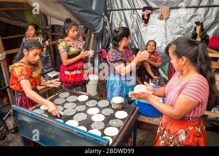 chichicastenango, Guatemala, 27 de febrero de 2020: Damas mayas en el mercado tradicional de fabricación de tortillas Foto de stock