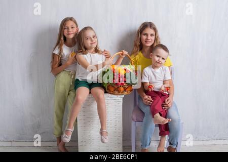 Muchacho y tres niñas con una canasta de frutas y verduras Foto de stock