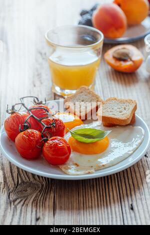 Desayuno vegetariano saludable o brunch. Huevos fritos caseros con tomates, frutas frescas de verano, bayas, café y zumo