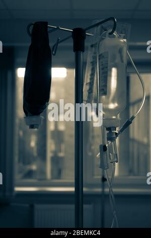 Los cuentagotas intravenosos están listos para su uso en una sala de hospital frente a la ventana. Foto en tonos verticales Foto de stock