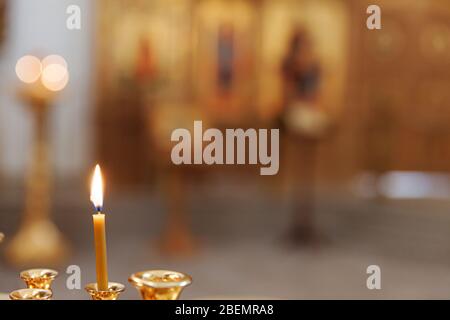 Iglesia Ortodoxa. Cristianismo. Decoración interior festiva con velas encendidas e icono en la iglesia ortodoxa tradicional en la víspera de Pascua o Navidad. Religión fe símbolo de oración