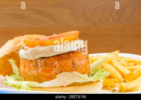 Big Salmon Burger con maionaise, frenche fritas y ensalada Foto de stock
