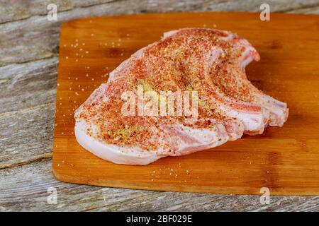 Filetes de cerdo crudos frescos en una tabla de cortar vista superior Foto de stock