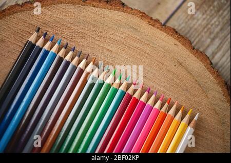 Vista de cerca de lápices de color arco iris sobre fondo de madera natural
