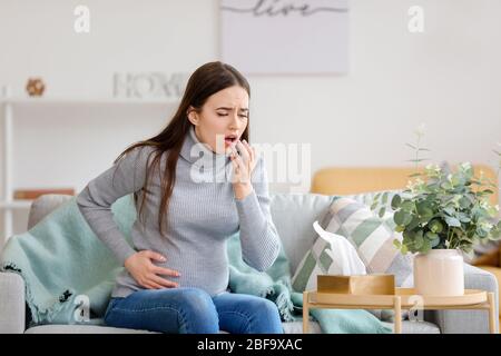 Toser mujer embarazada en casa Foto de stock