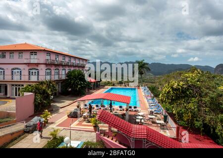 El edificio rosa del Hotel los Jazmines y su piscina junto al mirador turístico con vistas panorámicas al Valle de Vinales, Cuba