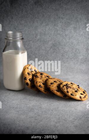 pila de galletas con trocitos de chocolate con una botella de leche
