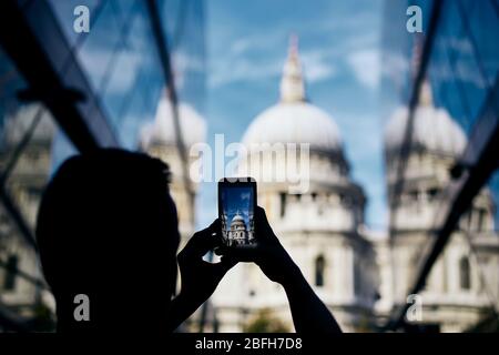 Hombre fotografiando con un teléfono inteligente. Turista tomando una foto de la Catedral de San Pablo en Londres, Reino Unido.