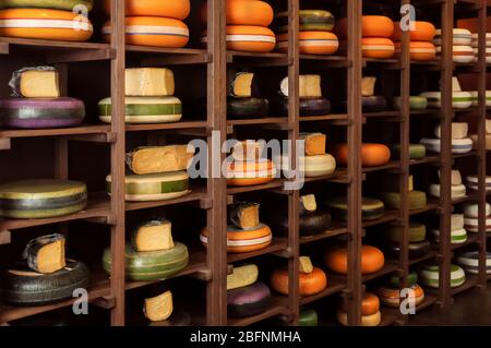 Puesto de madera con diferentes tipos de deliciosos quesos en la tienda Foto de stock