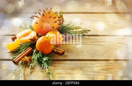 Composición de frutos, especias y ramas de coníferas sobre fondo de madera Foto de stock