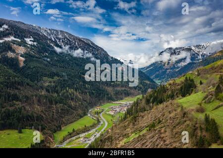Vista aérea de valle con verdes laderas de las montañas de Italia, Trentino, los árboles tumbados por un viento, nubes enormes sobre un valle, verde