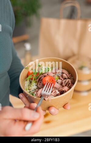 https://l450v.alamy.com/450ves/2bfy1b3/comida-para-el-hogar-alimentos-saludables-en-platos-desechables-un-hombre-come-comida-sana-enfoque-suave-2bfy1b3.jpg