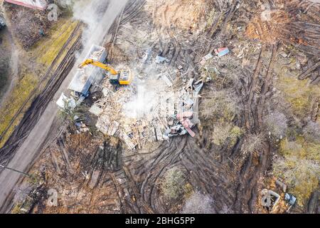 excavadora pesada en el sitio de un edificio demolido en la ciudad que ha sido despejado para su reurbanización. vista aérea arriba abajo Foto de stock