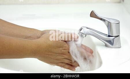 Lavarse las manos con agua antes de aplicar jabón, protección contra la infección por coronavirus COVID-19 Foto de stock