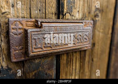 Caja de letras vieja de metal marrón oxidado. Buzón de correo vintage sobre fondo de madera con la palabra Cartas en relieve. Foto de stock