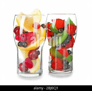 Vasos de bayas y frutas aislados sobre blanco Foto de stock