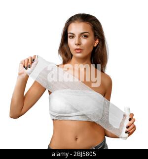 Mujer joven y hermosa con un vendaje en el pecho, sosteniendo una gasa, aislada sobre blanco Foto de stock