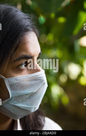 Una niña india que llevaba una máscara durante la pandemia de covid 19 mientras el bloqueo continúa en la India debido al brote del virus de la corona Foto de stock