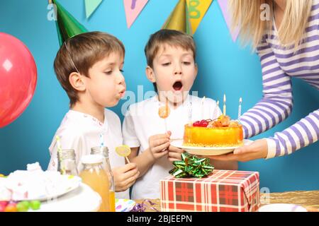 Unos gemelos pequeños y lindos que soplan velas en la tarta de cumpleaños  durante la fiesta Fotografía de stock - Alamy